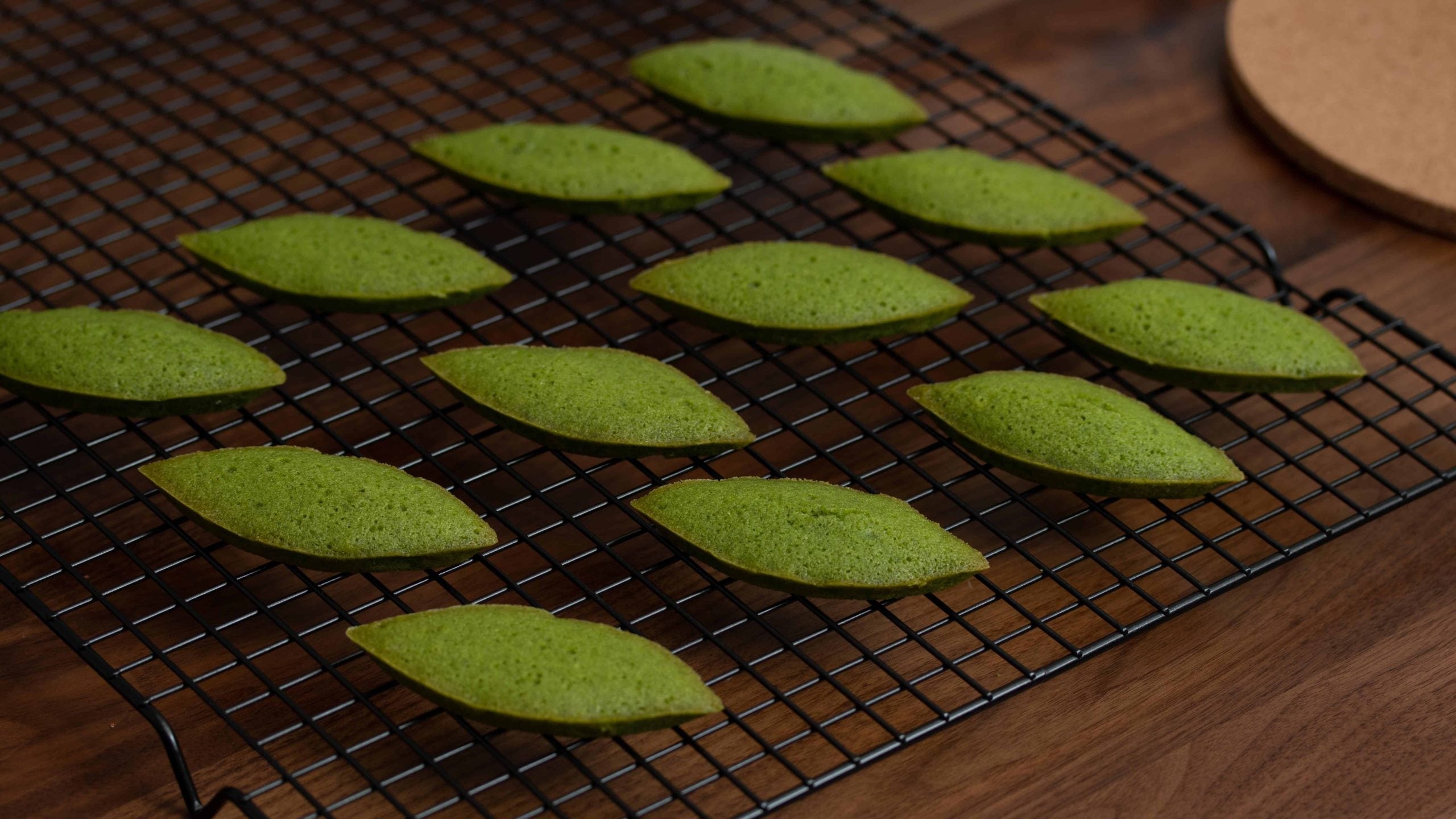 Green matcha financiers cooling on a wire rack