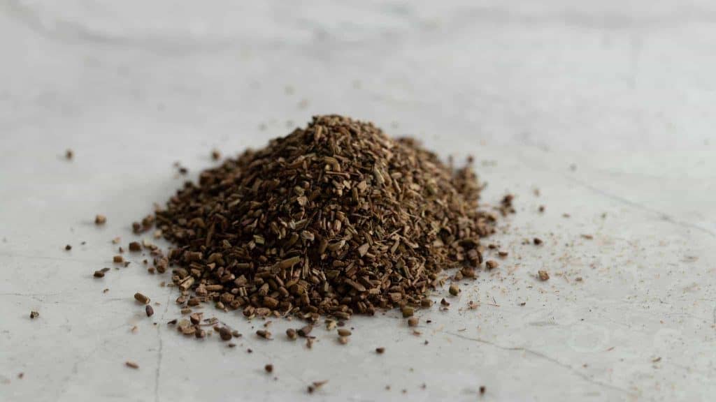 Pile of roasted hojicha tea leaves on a pale surface